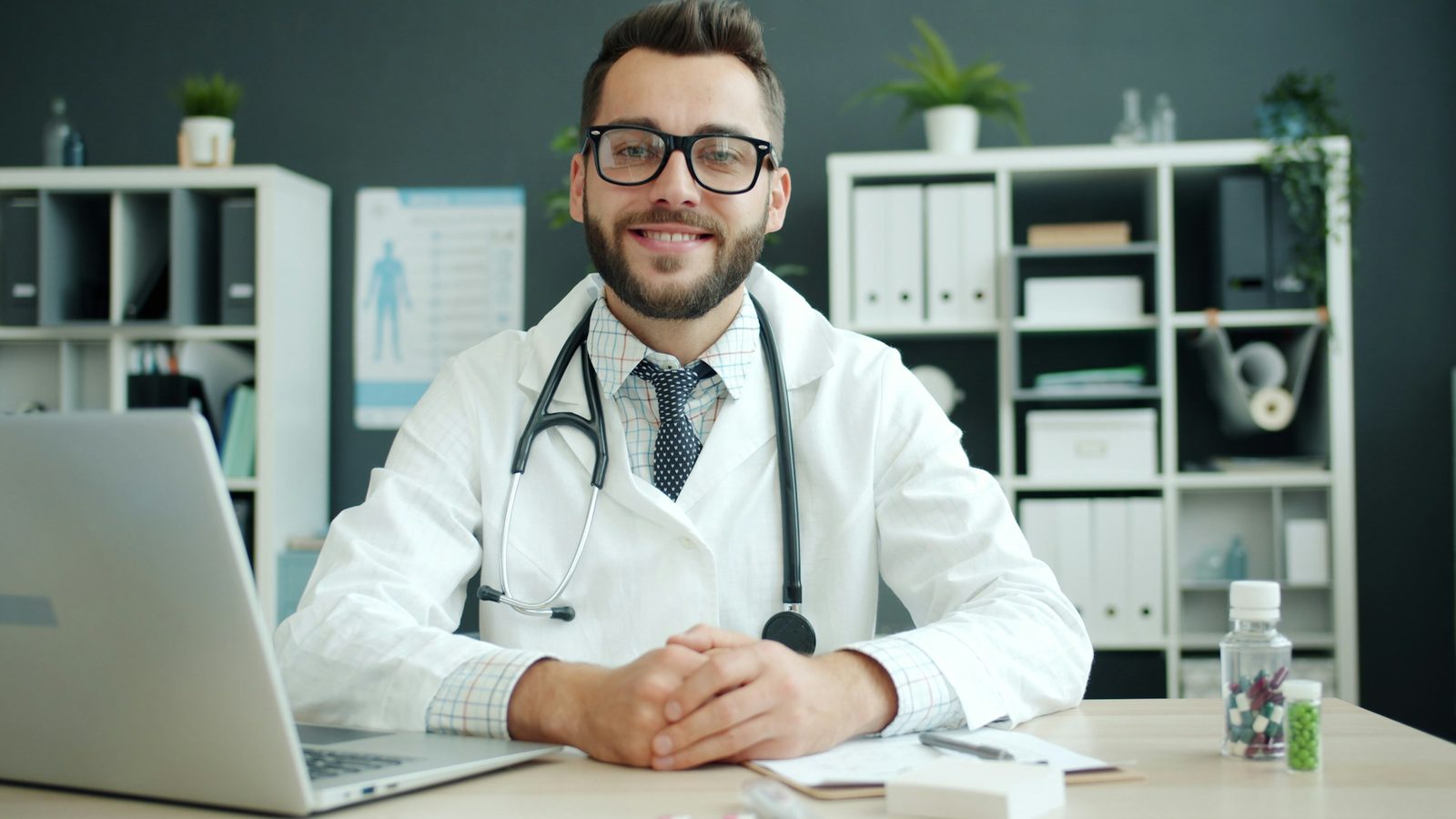 A doctor at their desk with a laptop, ready for a video consult